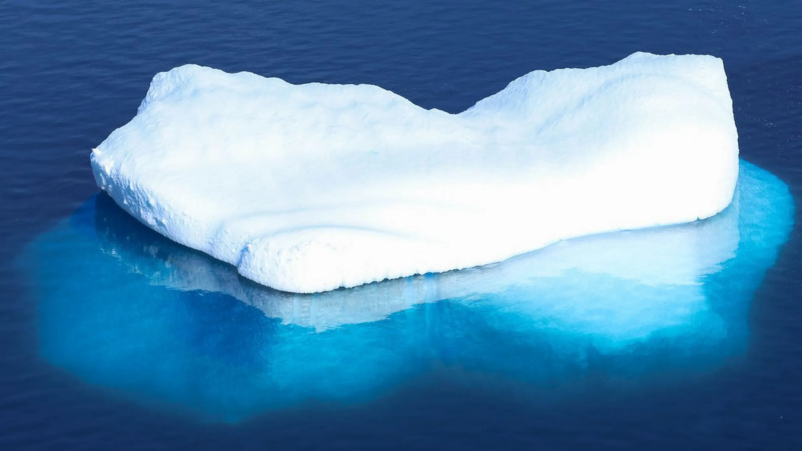 Ancient iceberg adrift in silver arctic waters