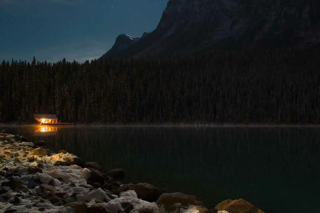 Glowing lakeside cabin reflected in the midnight-still surface of Lake Louise — Alberta Canada fine art print