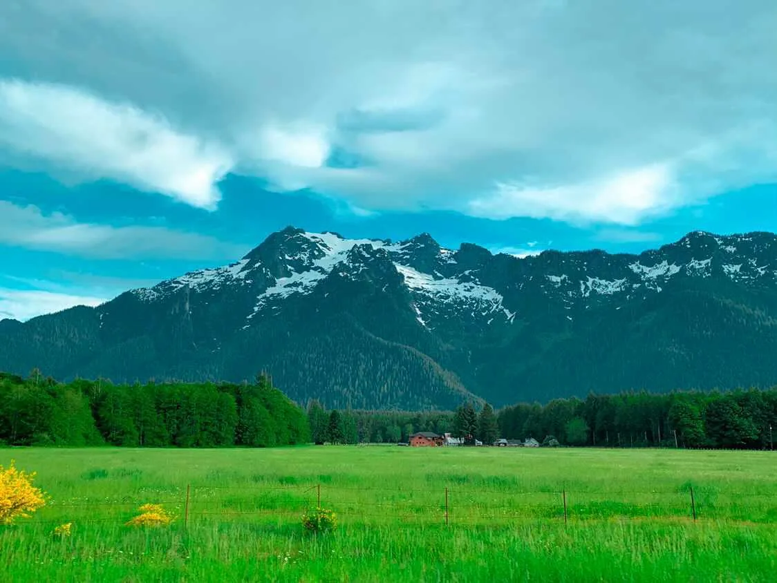Vivid green valley and farmstead beneath stormy Cascade Mountain peaks — Washington fine art print